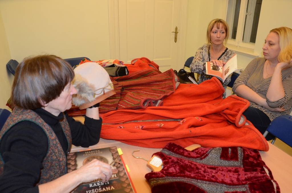 Pie galda ar muzeja krājuma un 